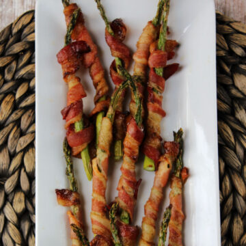 Bacon wrapped asparagus on a white plate