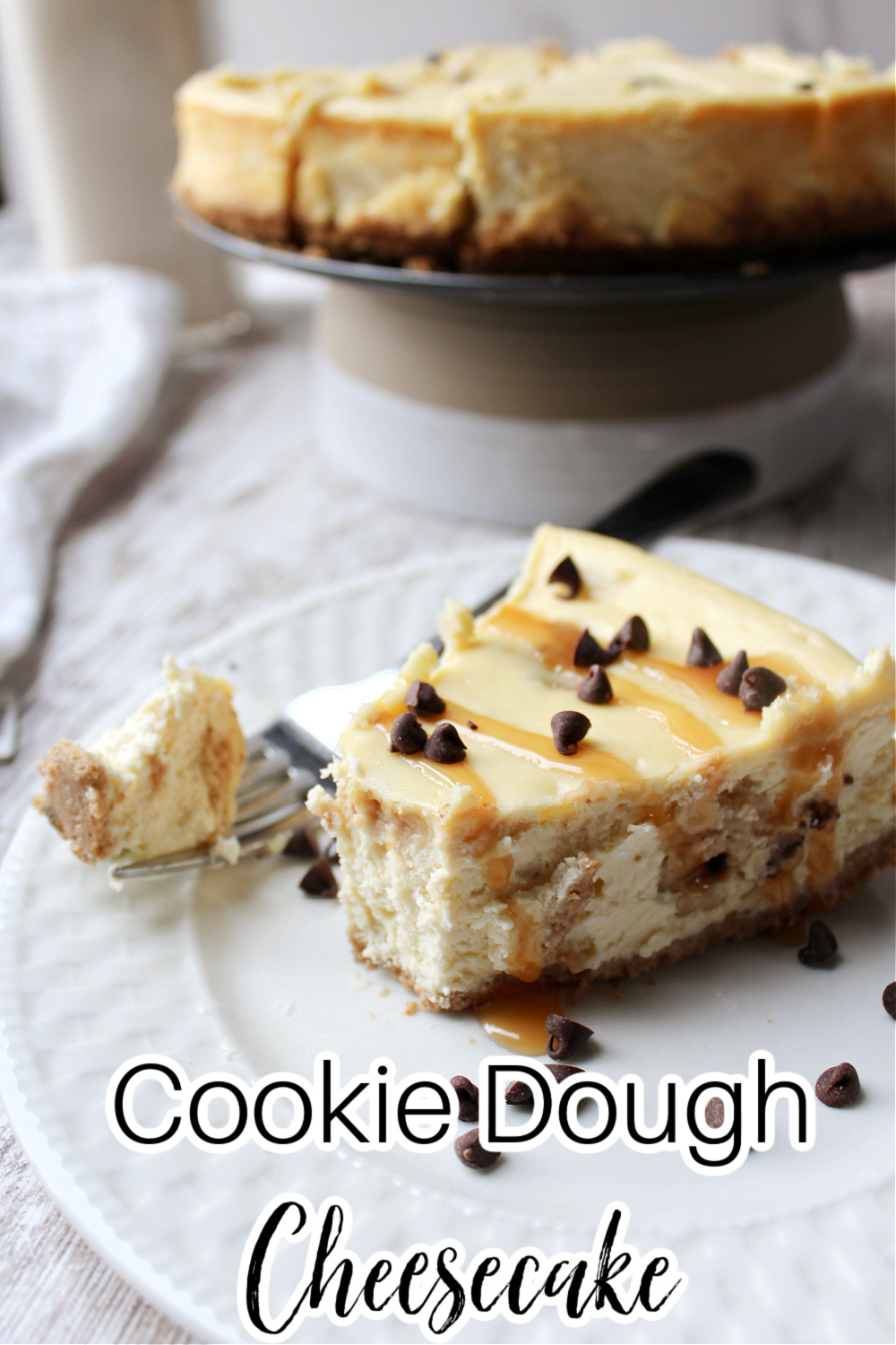 cookie dough cheesecake on a white plate with milk glass behind. 