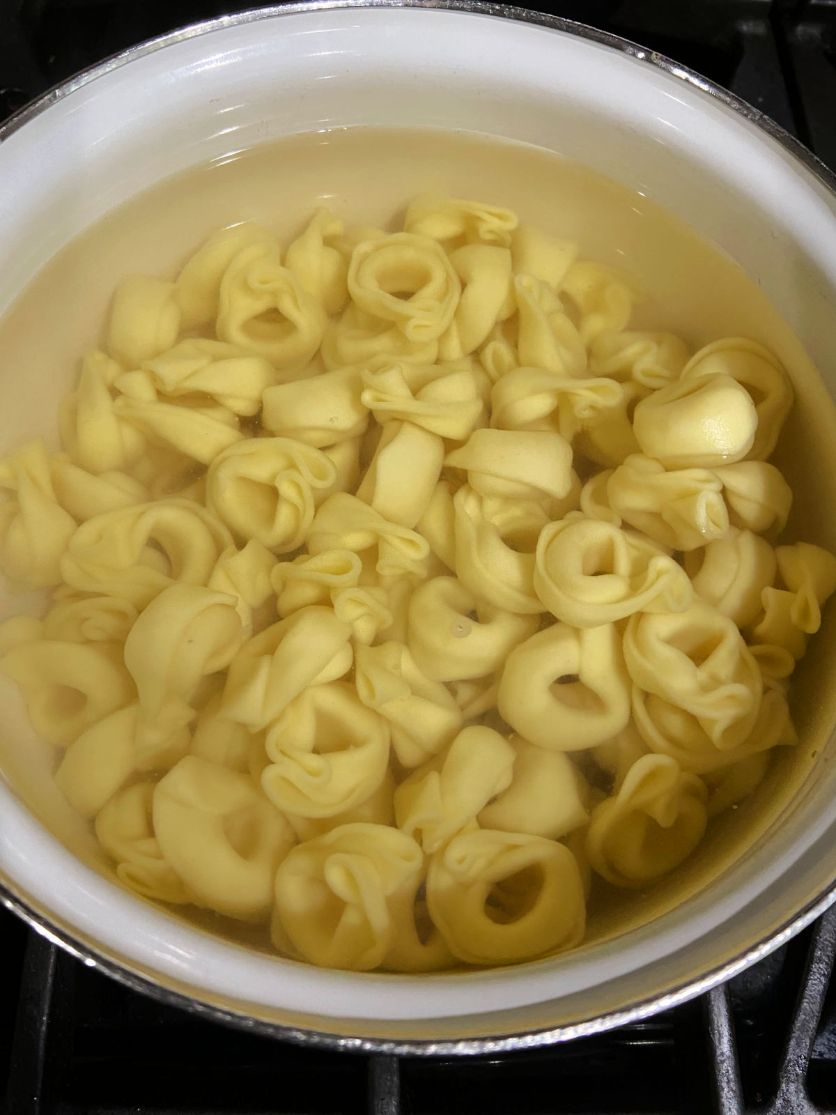 Boiling cheese tortellini in a pot of water. 