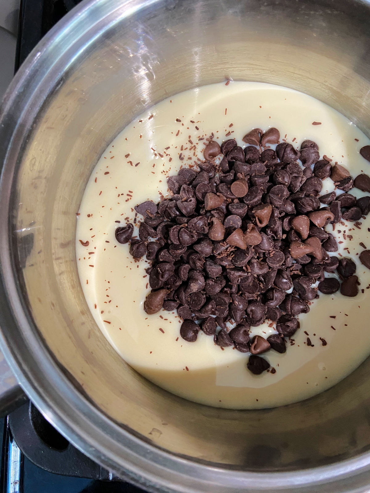 Sweetened condensed milk and milk chocolate chips together in a medium saucepan.