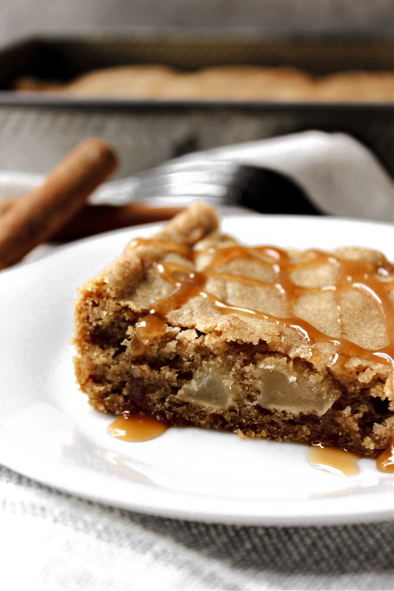 apple cake with caramel drizzle on a white plate. 