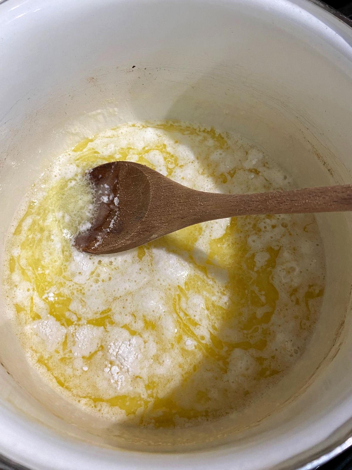 Butter melting in a large white pot.