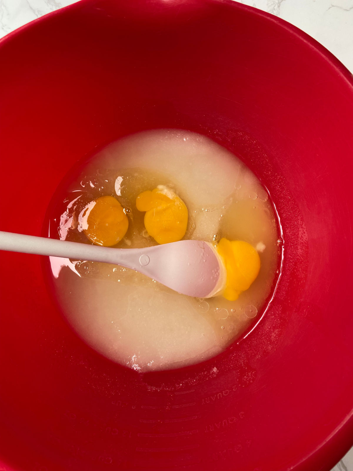 eggs and sugar in a red bowl. 