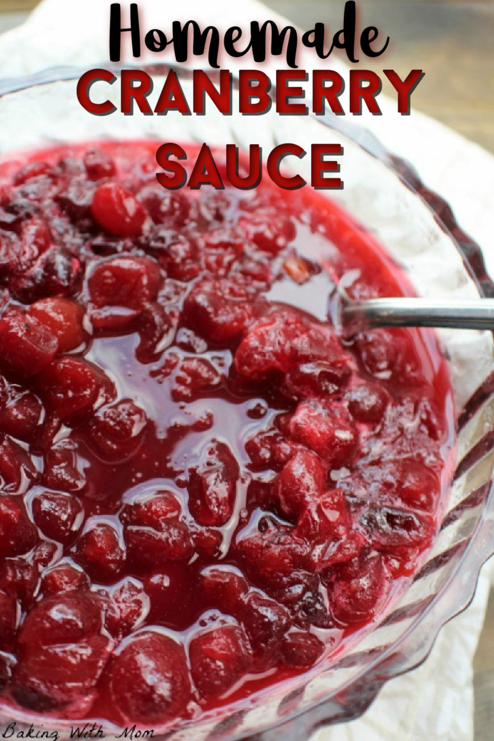 Cranberry sauce in a clear bowl with a towel laying besides
