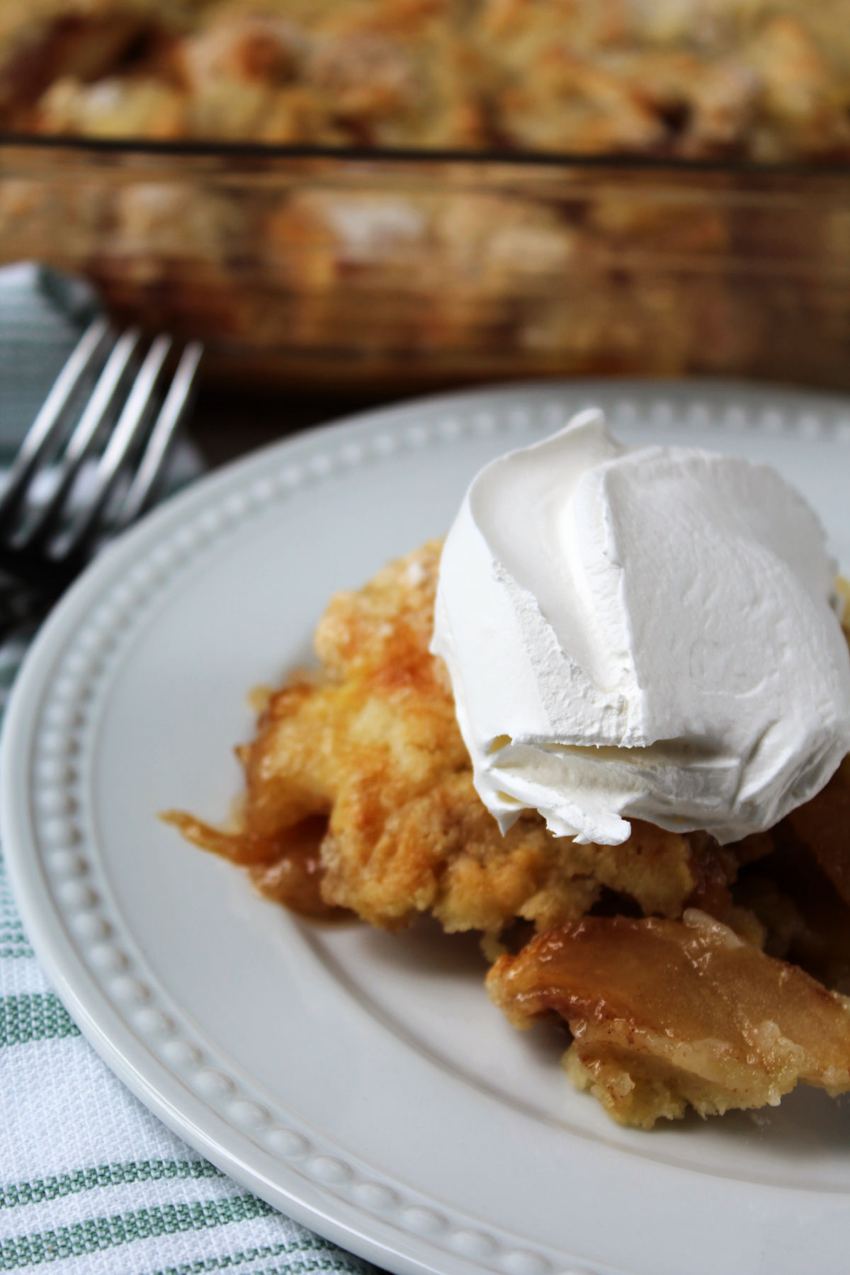 Scoop of apple crumble on a white plate.