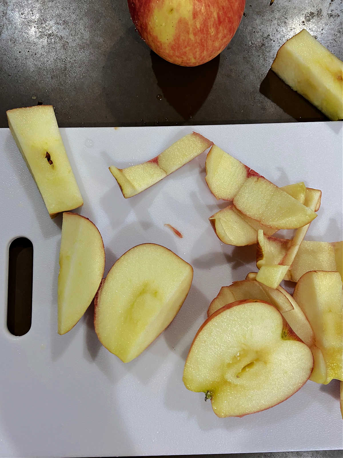 Red apples sliced on a cutting board. 