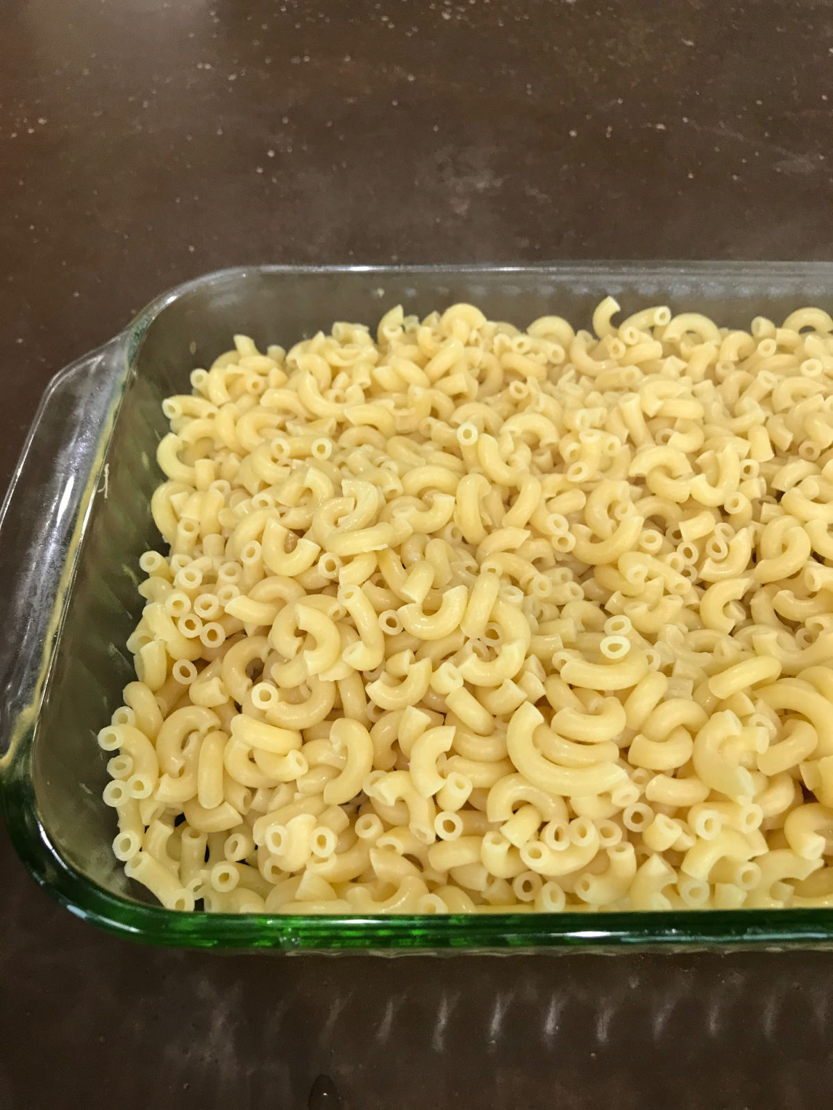 Cooked elbow macaroni in a clear casserole dish. 