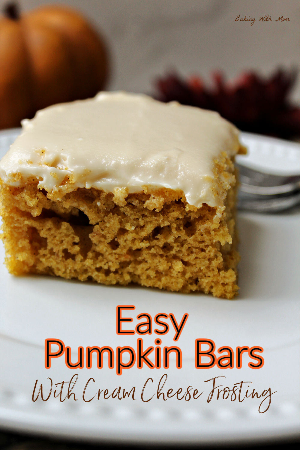 Pumpkin bars with cream cheese frosting on a white plate. 