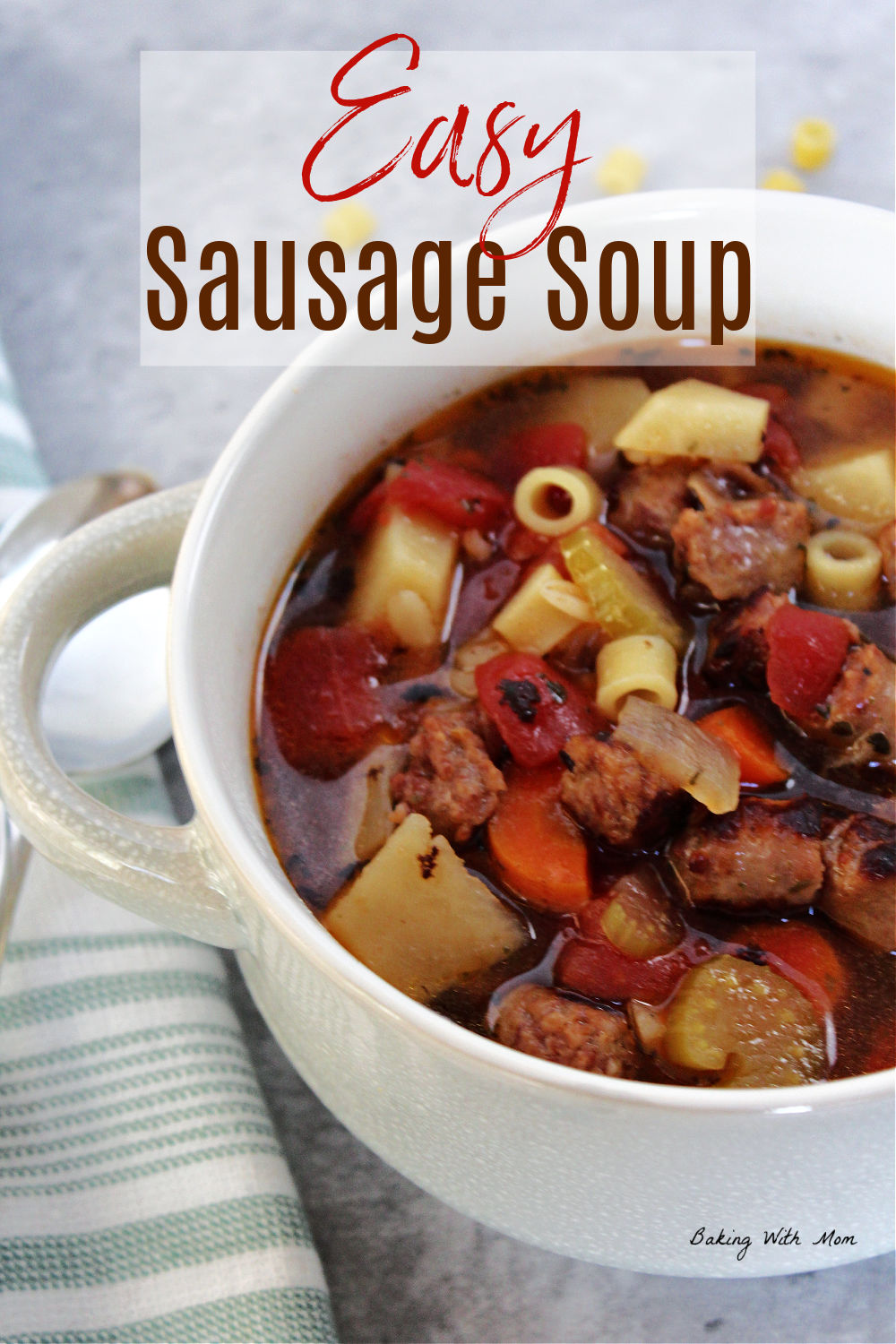 Bowl of sausage soup with a green and white towel laying besides. 