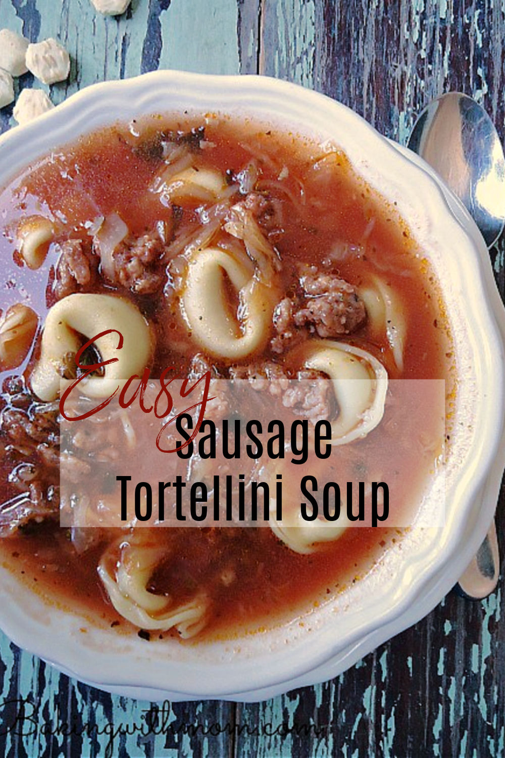 Bowl of sausage soup with a spoon laying besides.