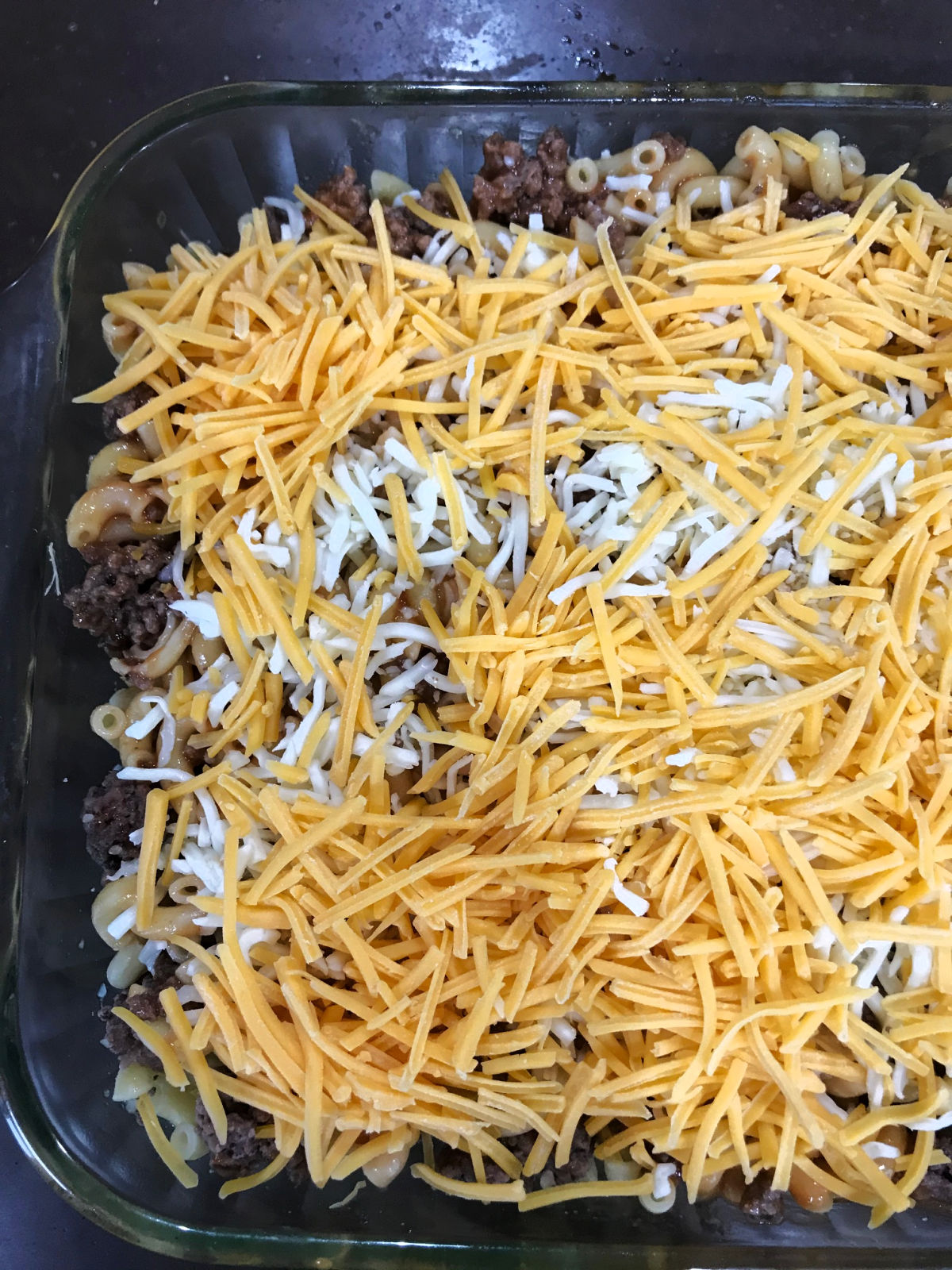 shredded cheese on top of unbaked hamburger casserole.