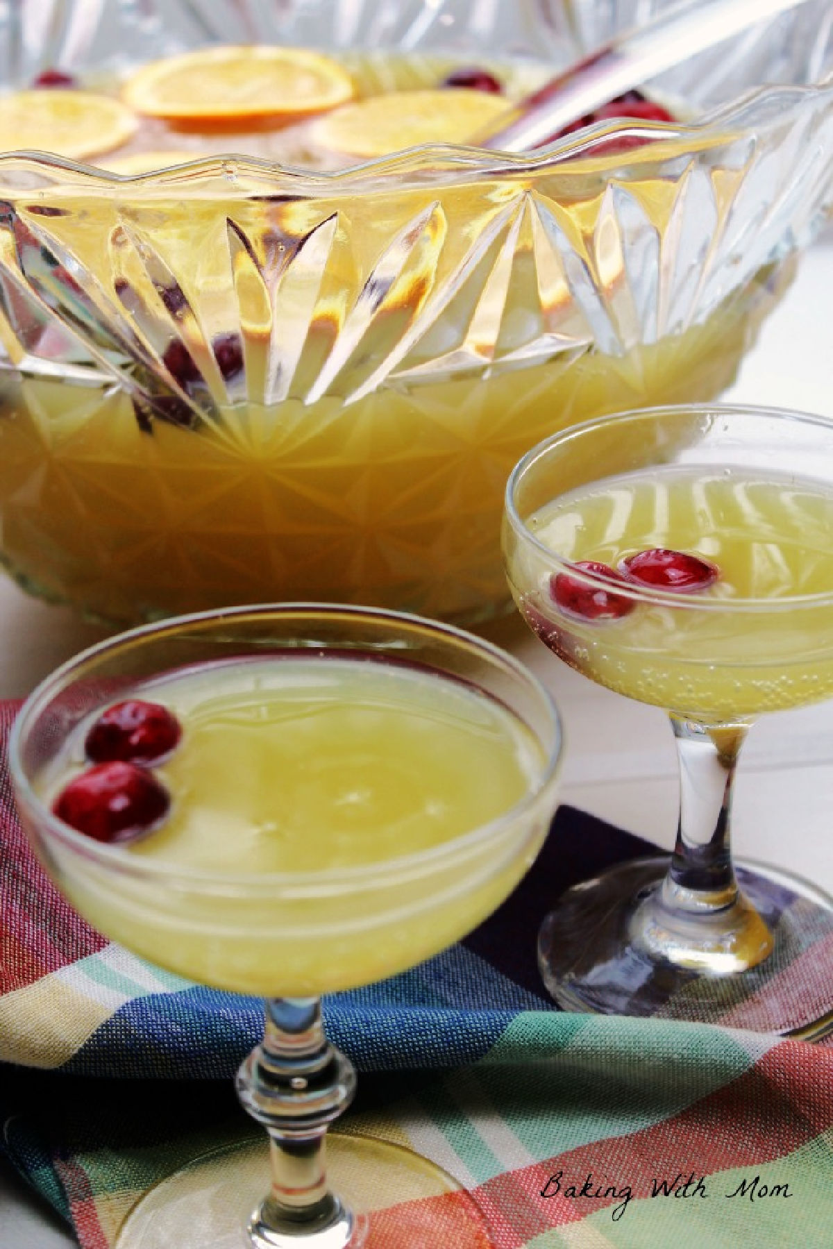 Punch bowl of holiday punch with punch glasses in front. 