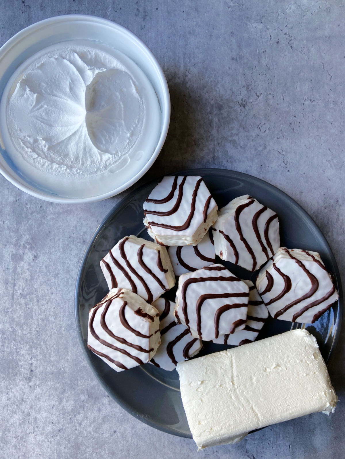 cream cheese, zebra cakes and whipped cream on a plate. 