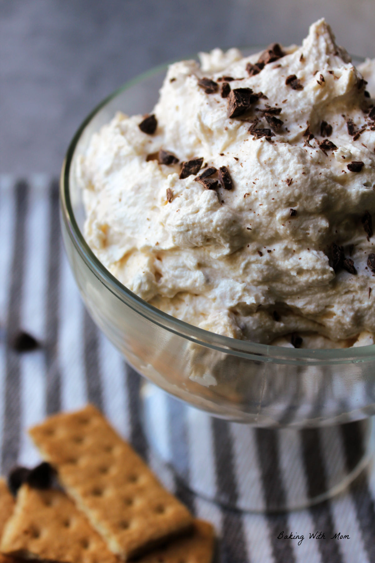 Zebra cake dip in a clear bowl with graham crackers laying nearby. 