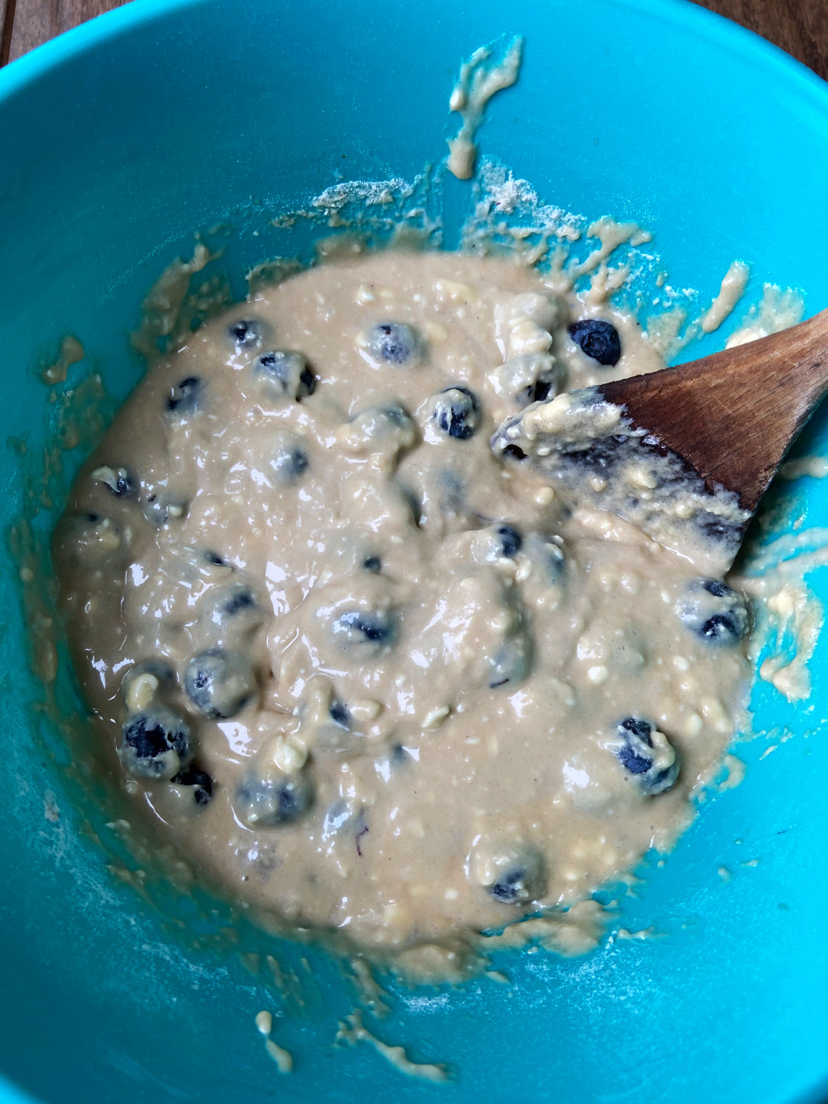 Blueberries in batter in a blue bowl. 