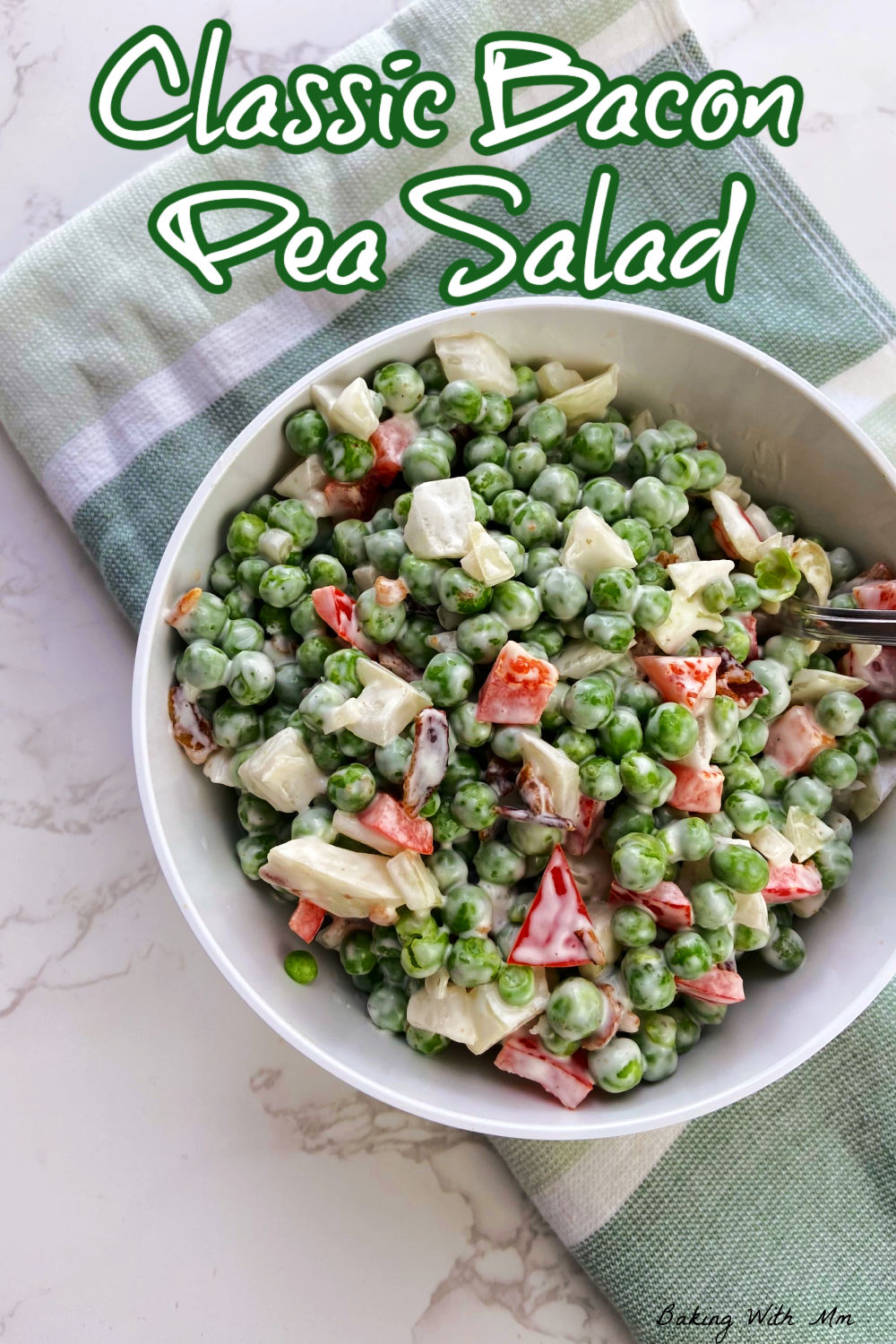 Pea salad in a bowl with chunks of onions, peppers and bacon. 