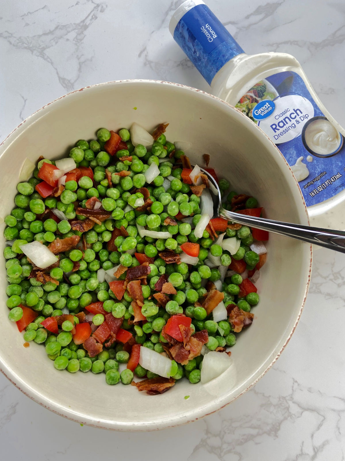 pea salad in a bowl with chopped veggies and bacon. 