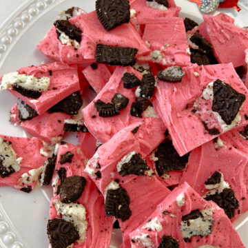 pink almond bark with oreos on a white plate