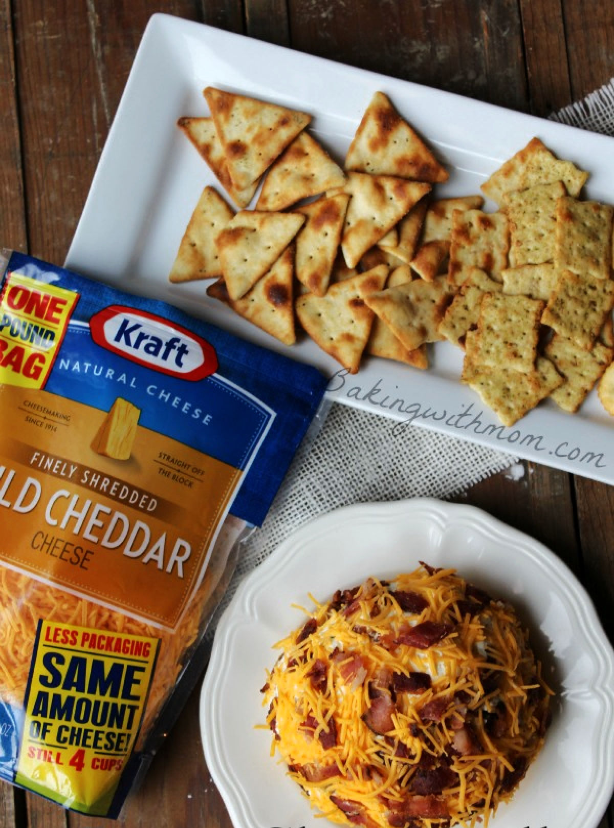 Bacon cheese ball on a white plate and Kraft cheese package laying beside. 