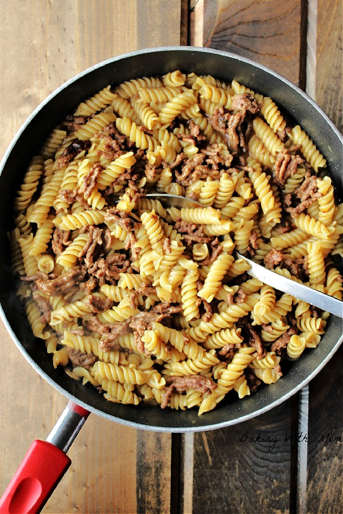 Hamburger helper beef pasta in a frying pan with a spoon. 