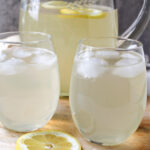 homemade lemonade in two glasses with a lemon.