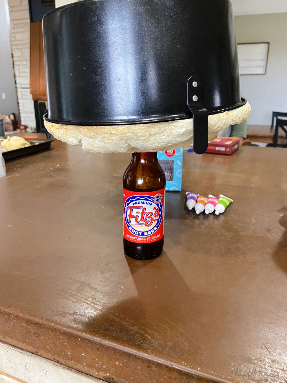 Fitz root beer bottle holding up an overturned angel food cake. 