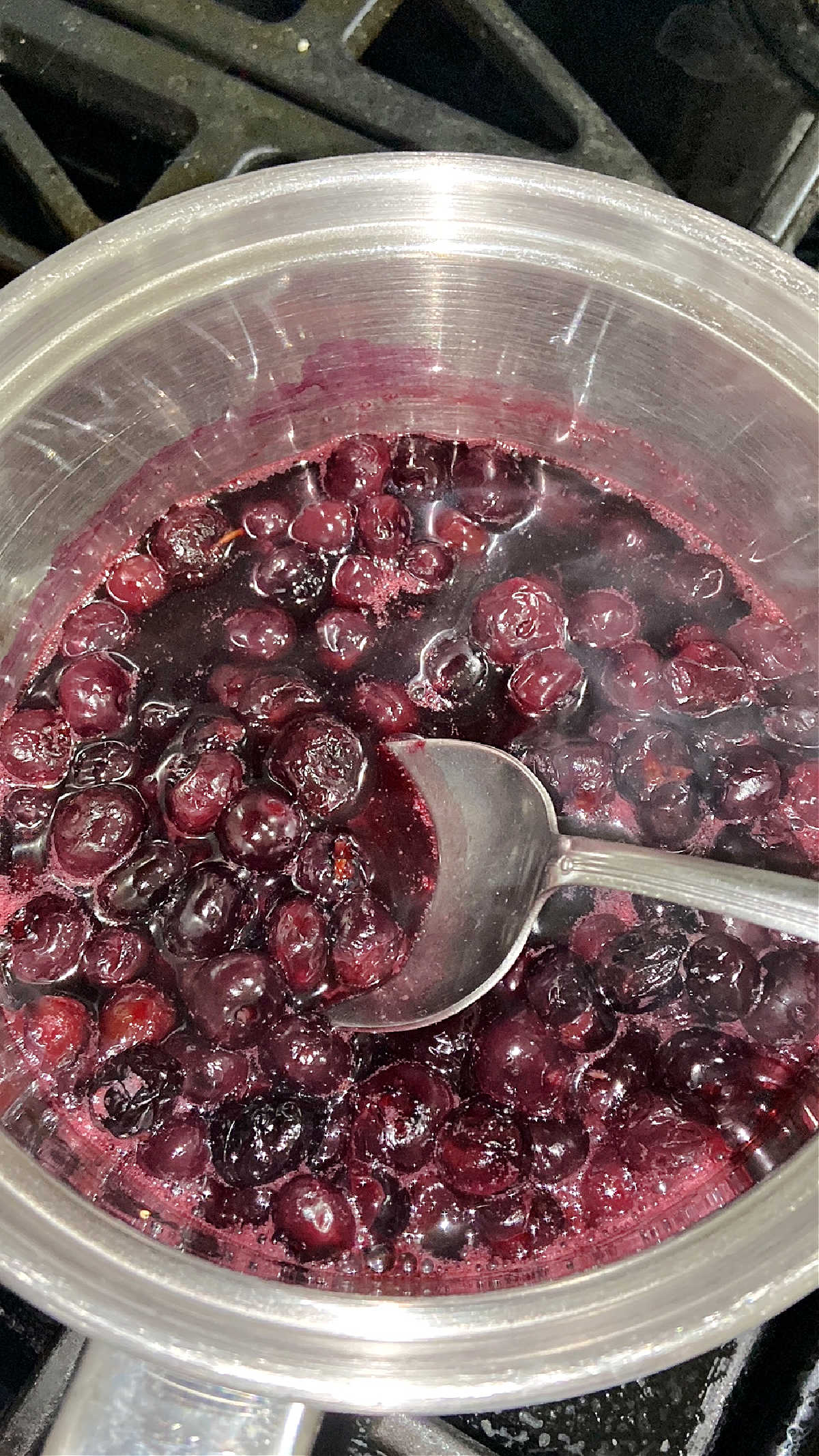 Blueberries boiling on a pot on the stove. 