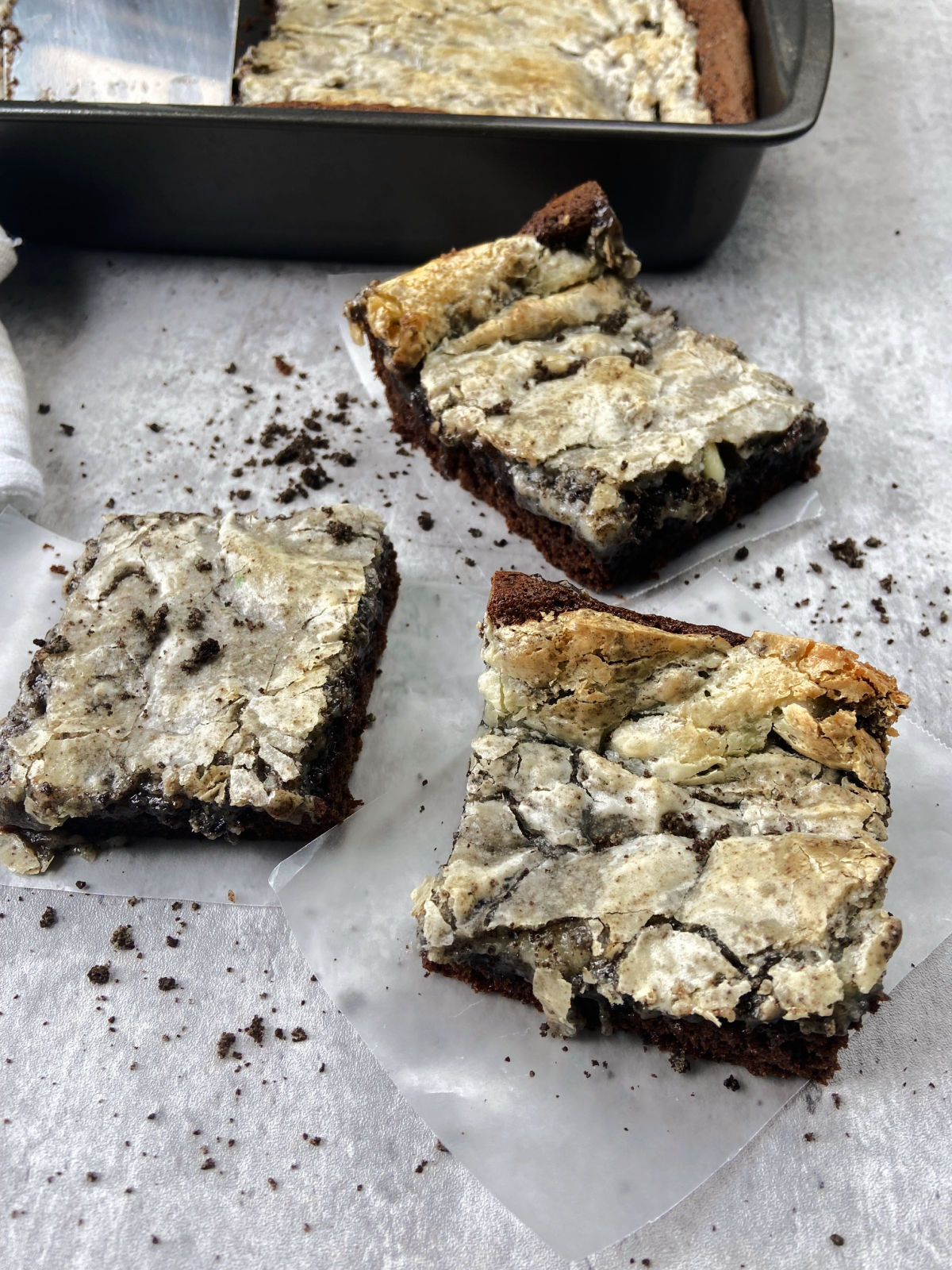Cookies and cream gooey butter cake slices on wax paper. 