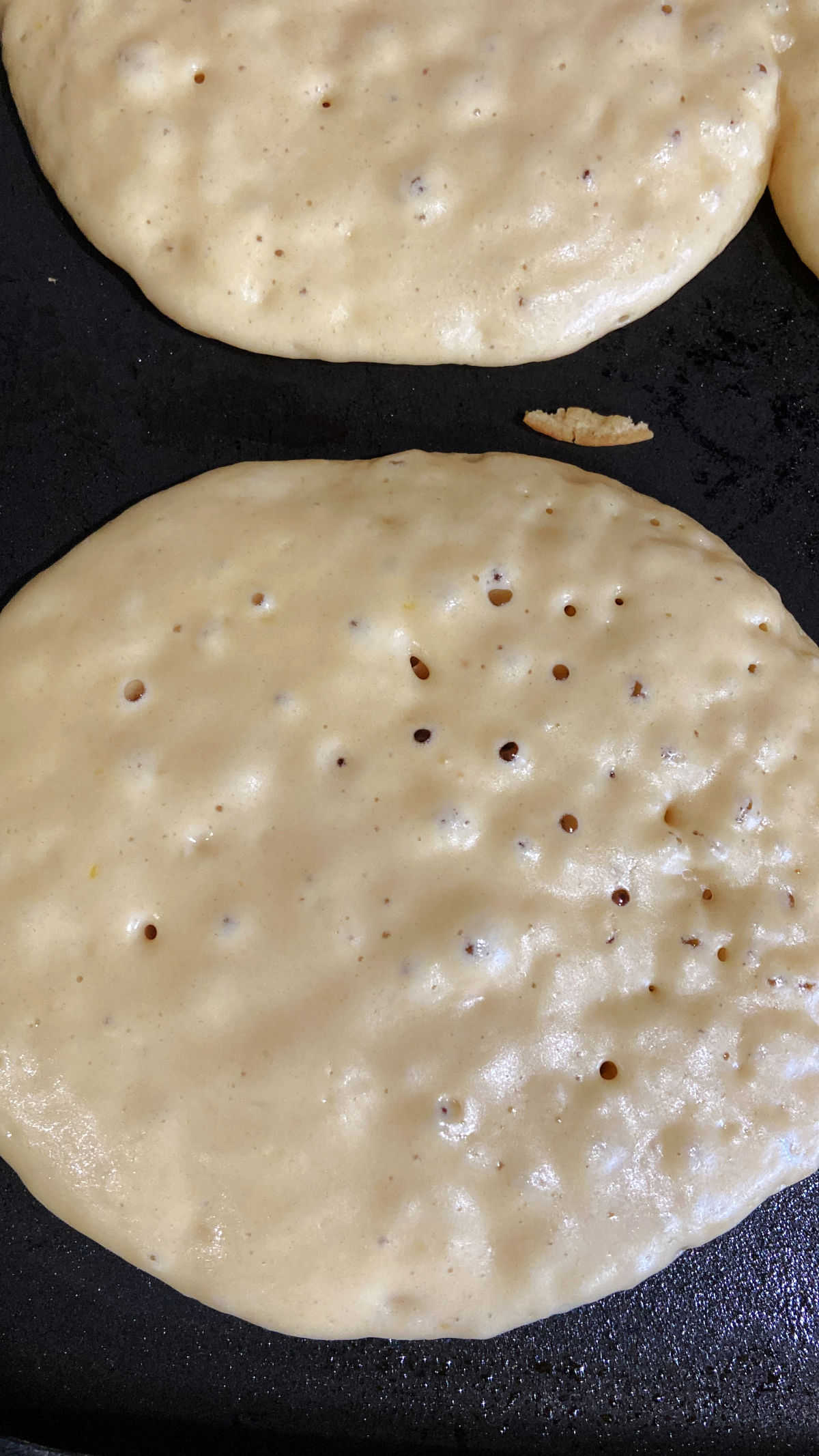 Pancakes on a skillet being cooked. 