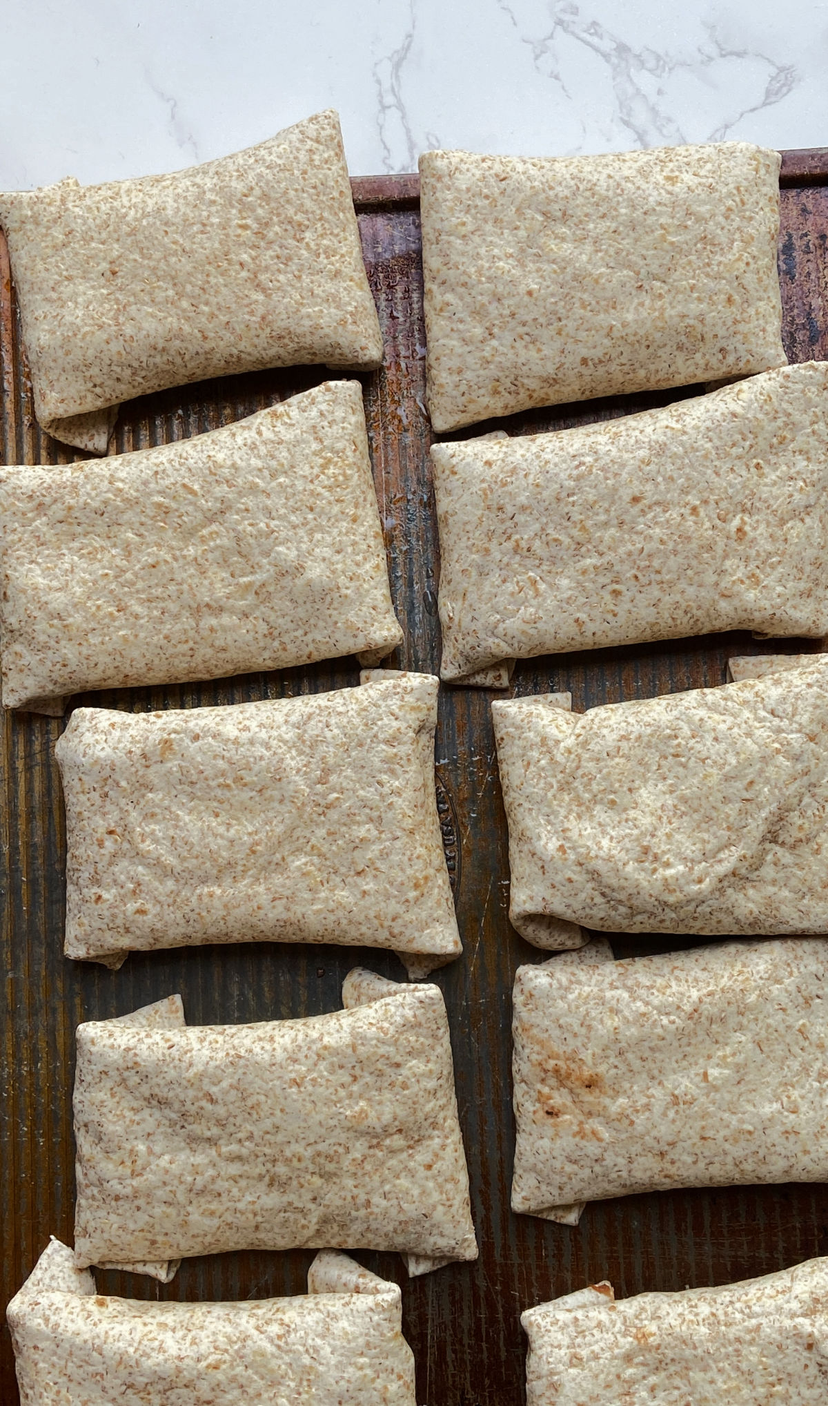 Burritos on a cookie sheet. 