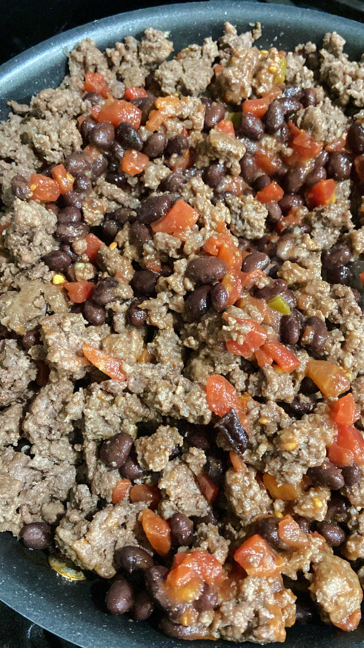 hamburger, tomatoes, beans in a frying pan. 