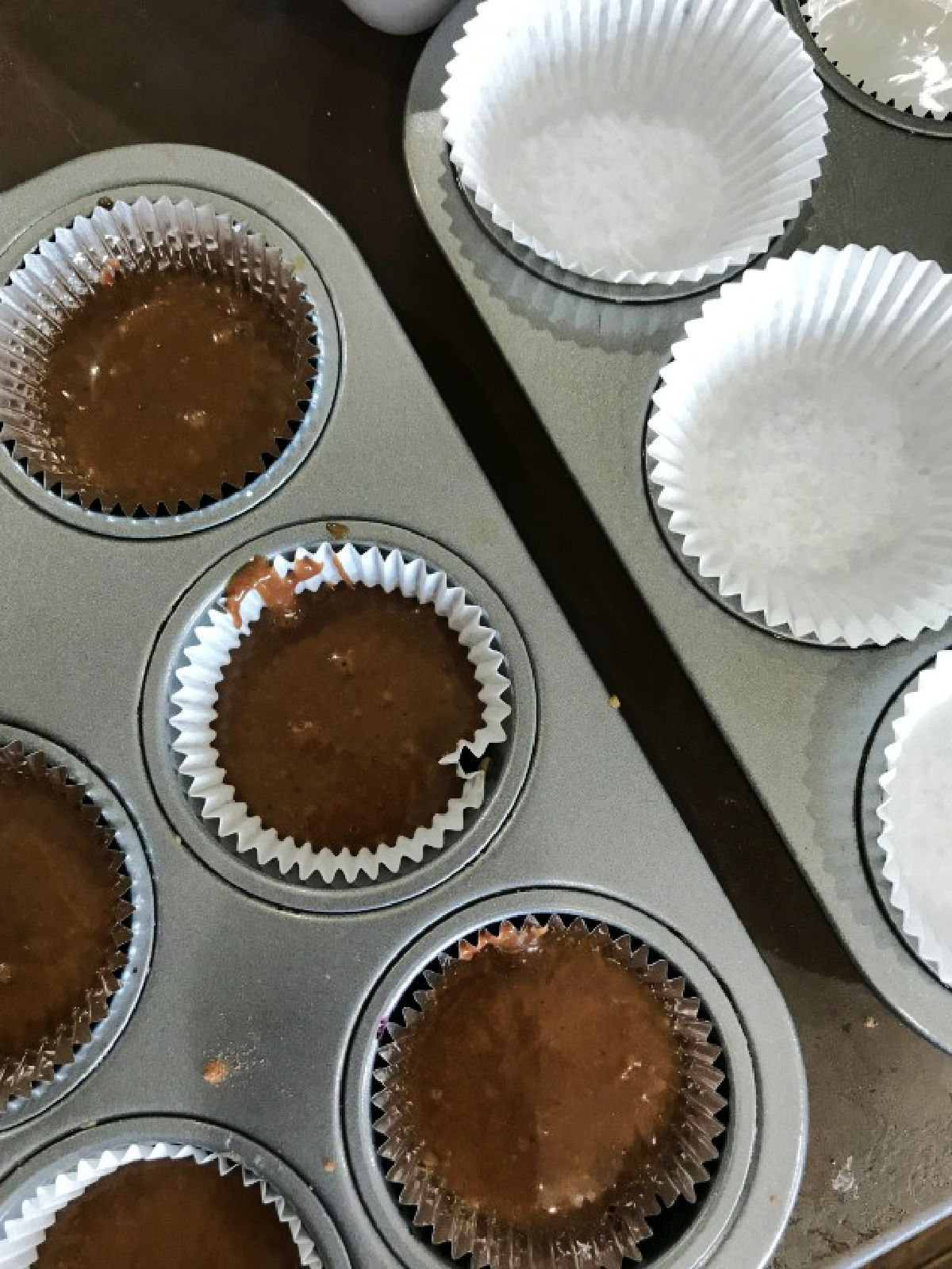 Cupcake batter in a lined muffin tin. 