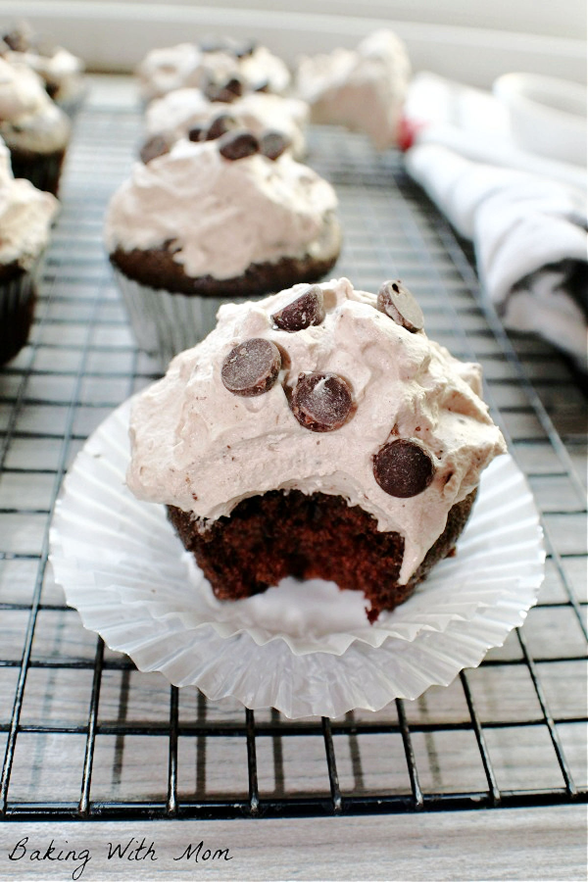 A devil's food cupcake on a cooling rack. 