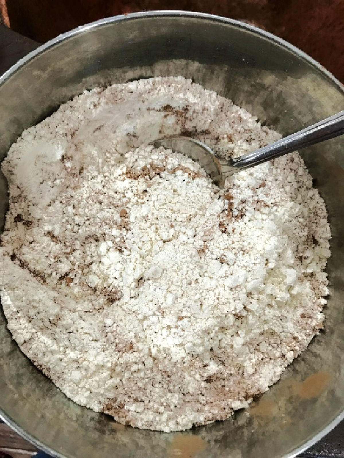 Flour and cocoa in a stainless steel bowl. 