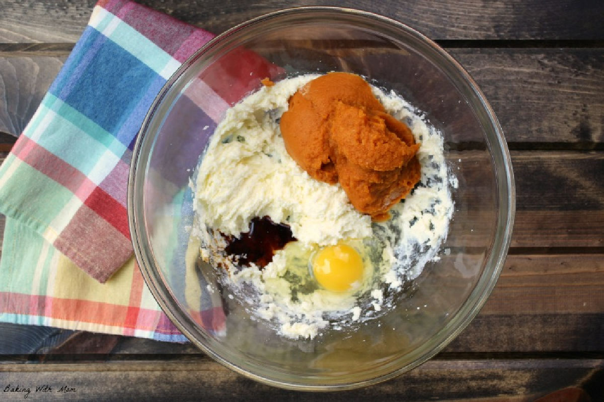 egg, pumpkin puree and ingredients in a clear mixing bowl. 