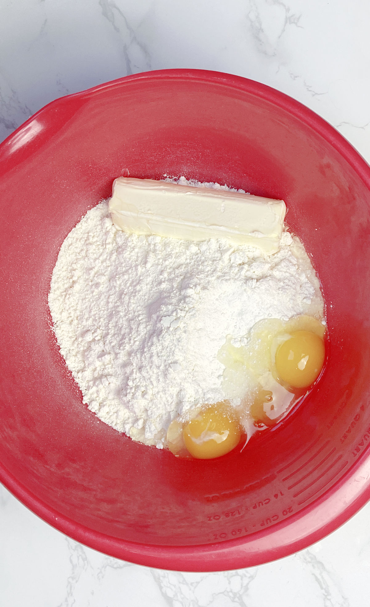 cake mix and eggs in a red bowl. 