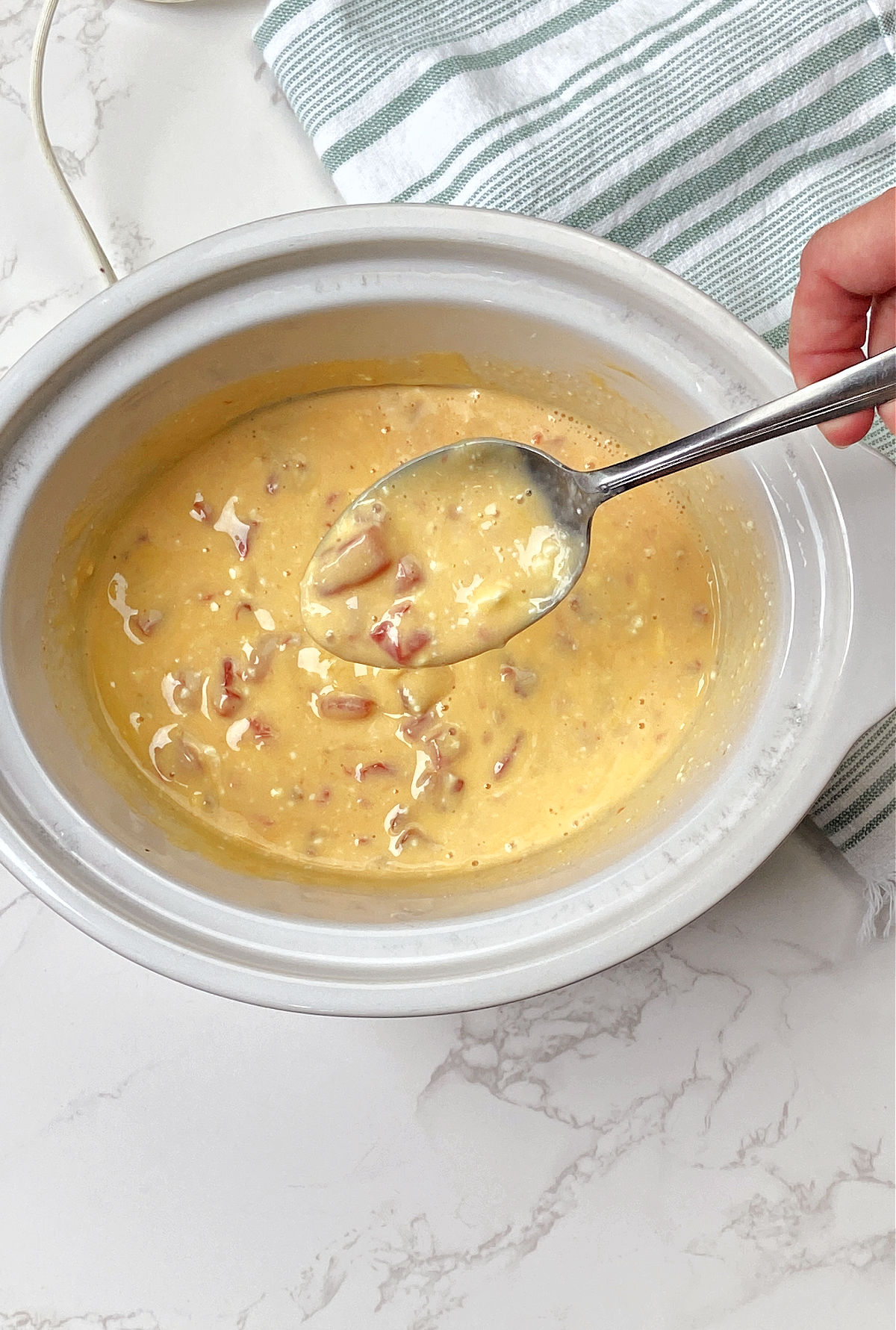 cheese dip in a white crock pot. 