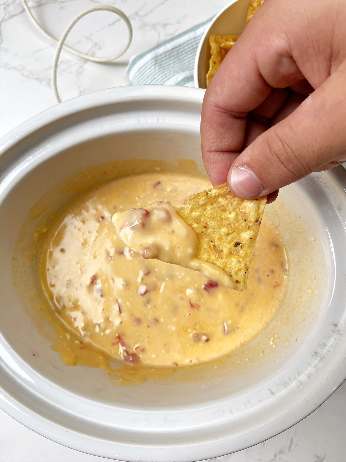 Melted cheese dip with a tortilla chip. 