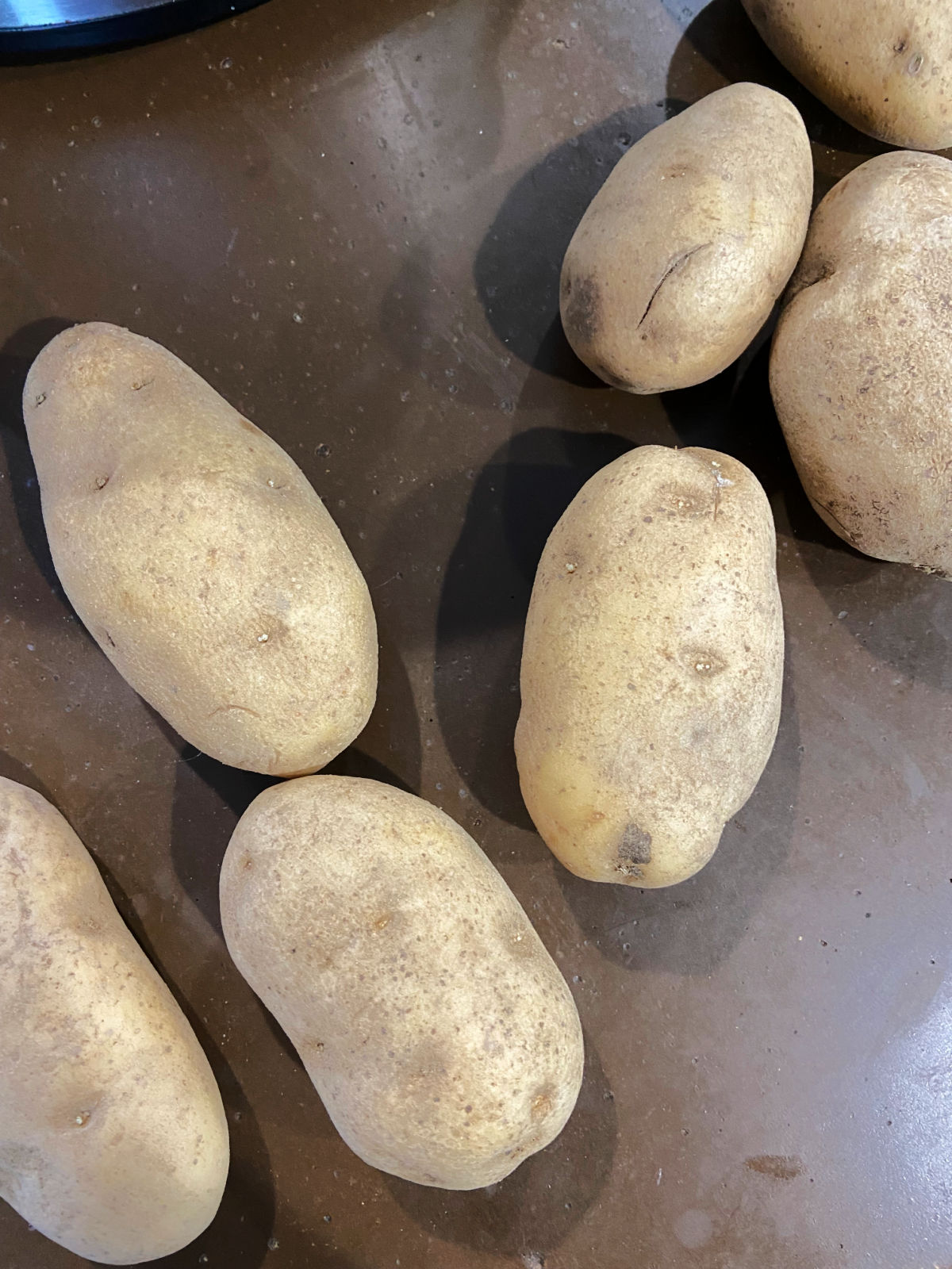 Unpeeled potatoes on the counter.