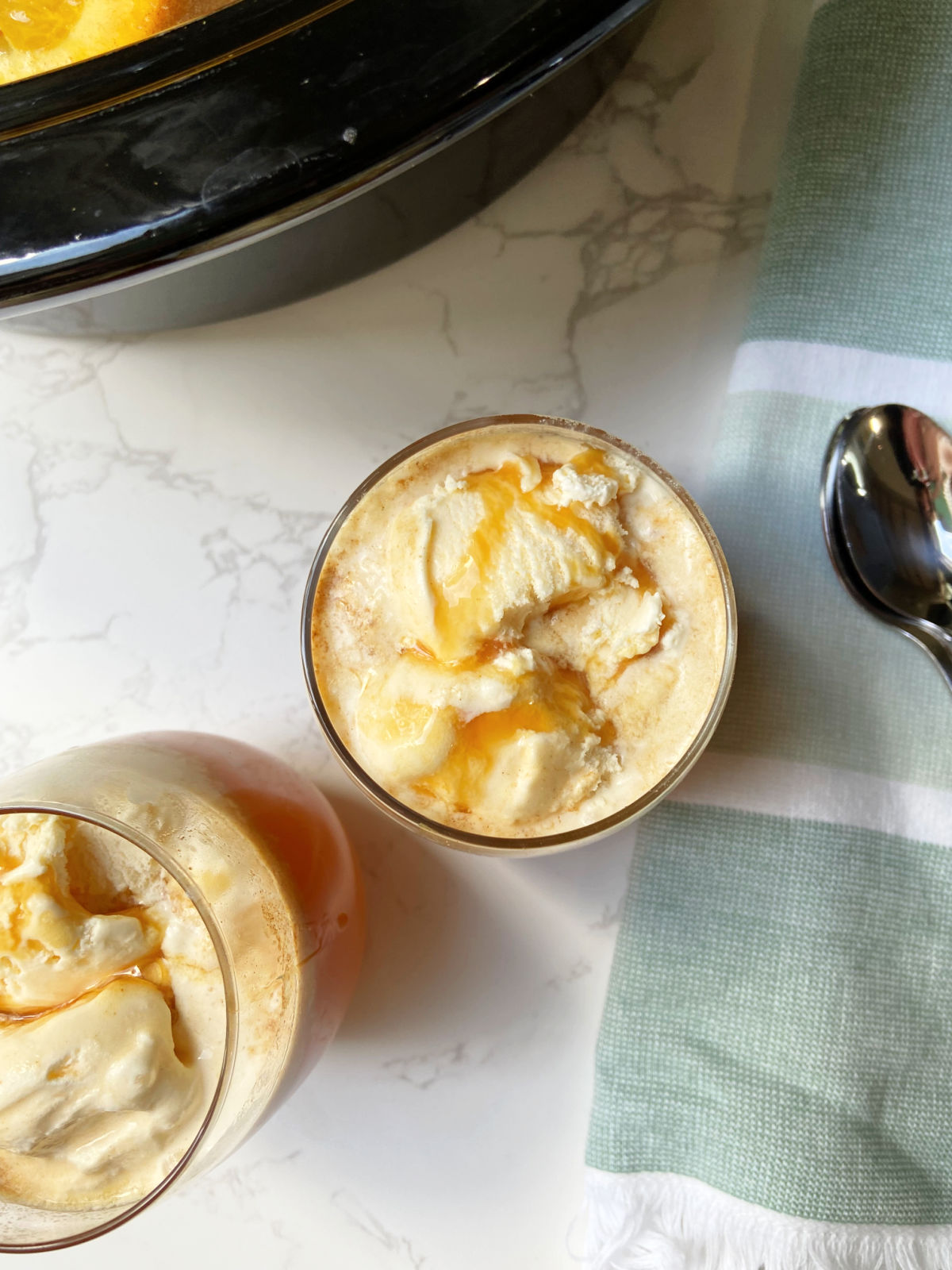 Caramel drizzled on top of vanilla ice cream with apple cider. 