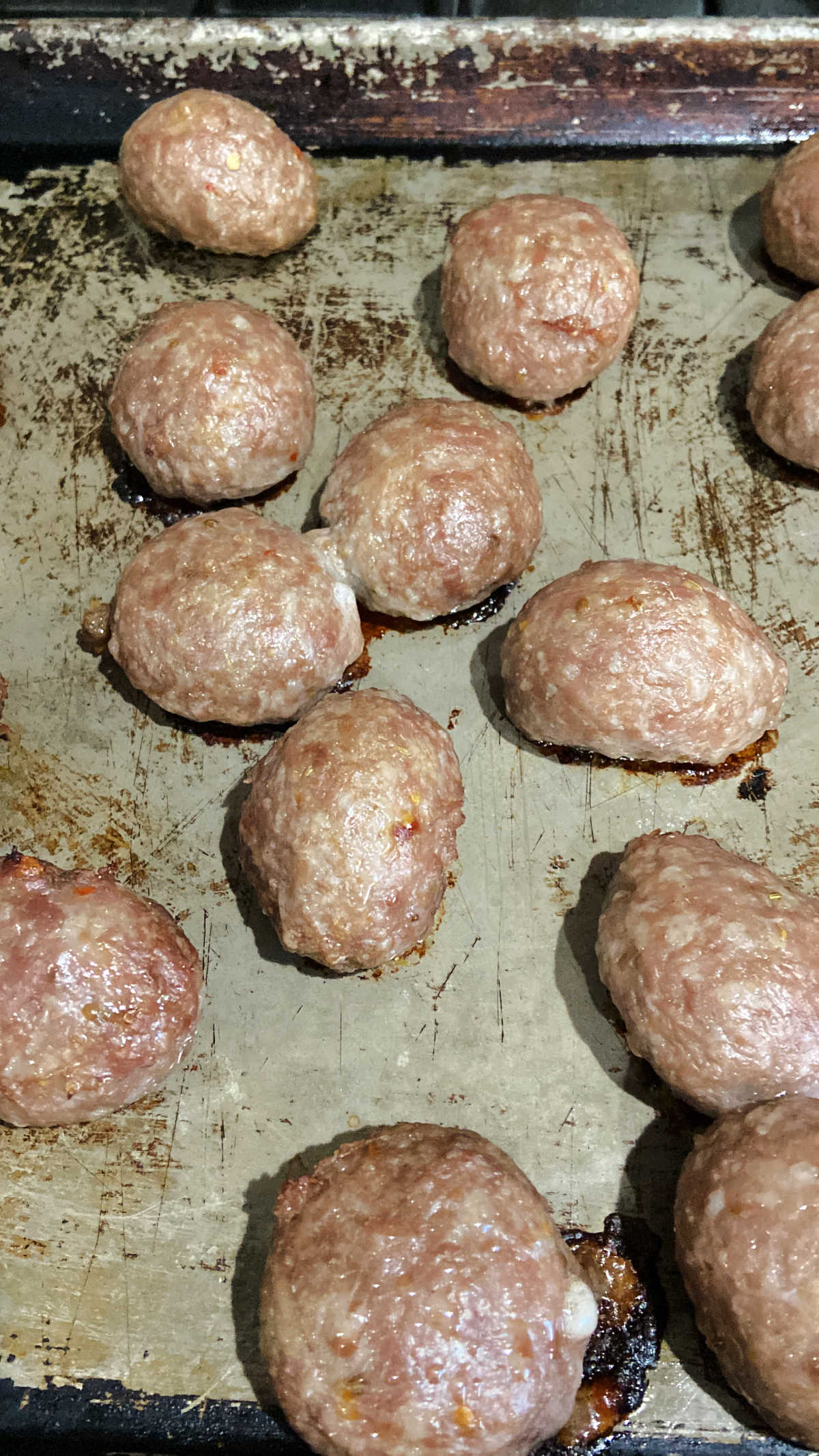 cooked meatballs on a baking sheet.