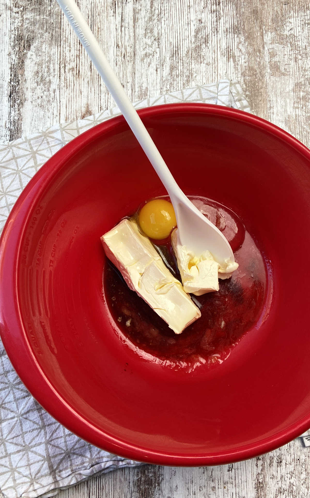 butter and egg in a red bowl.