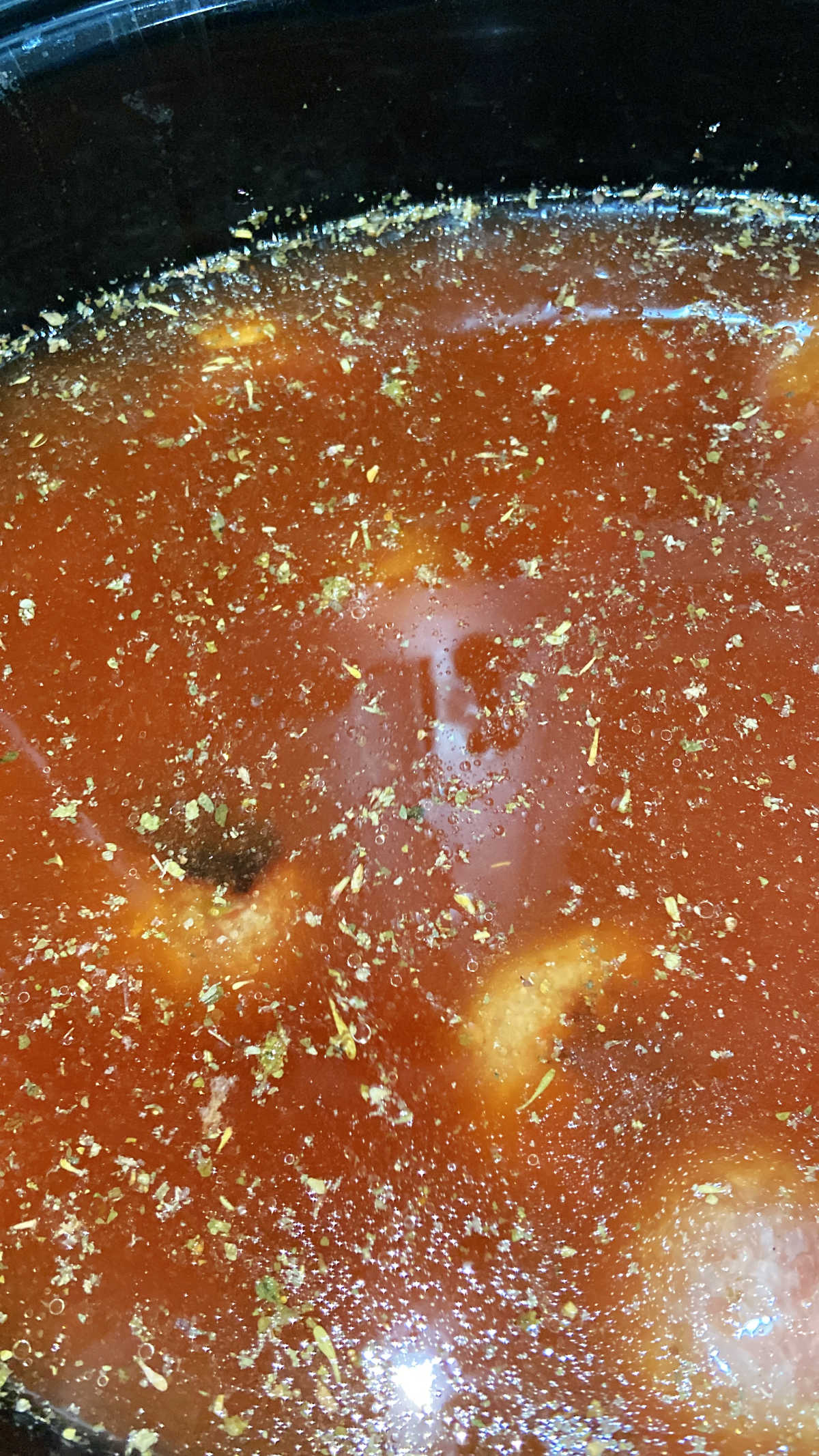 beef broth in a crock pot with meatballs.