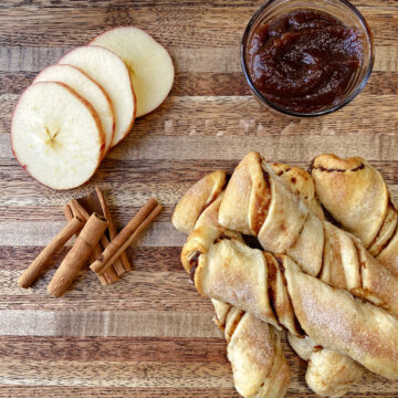 twists on a cutting board with apples and apple butter and cinnamon.