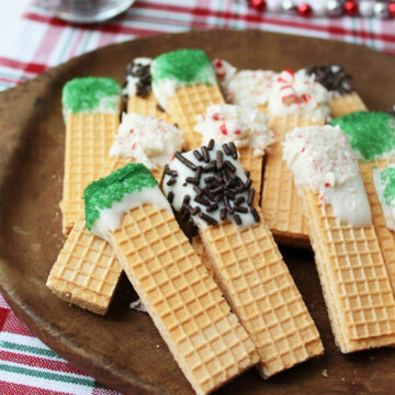 Christmas wafer cookies on a brown serving tray.