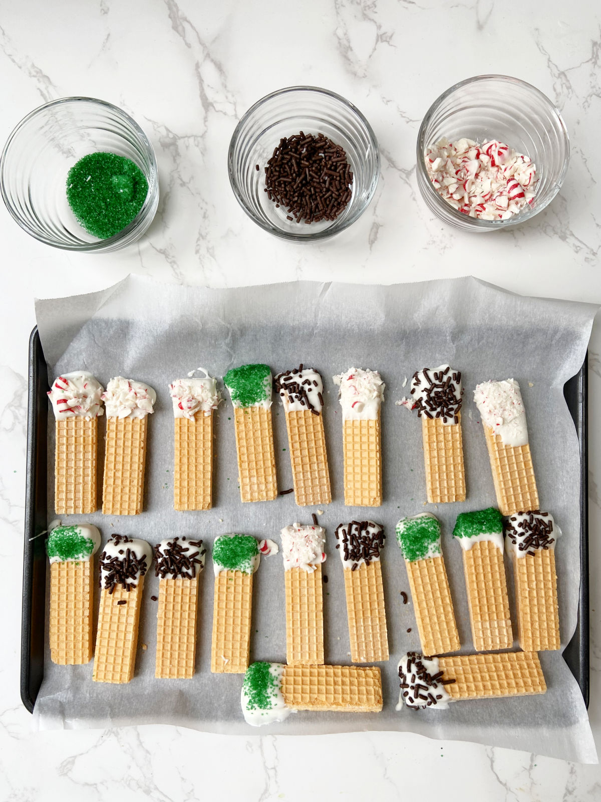 wafer cookies on a cookie sheet and toppings nearby. 