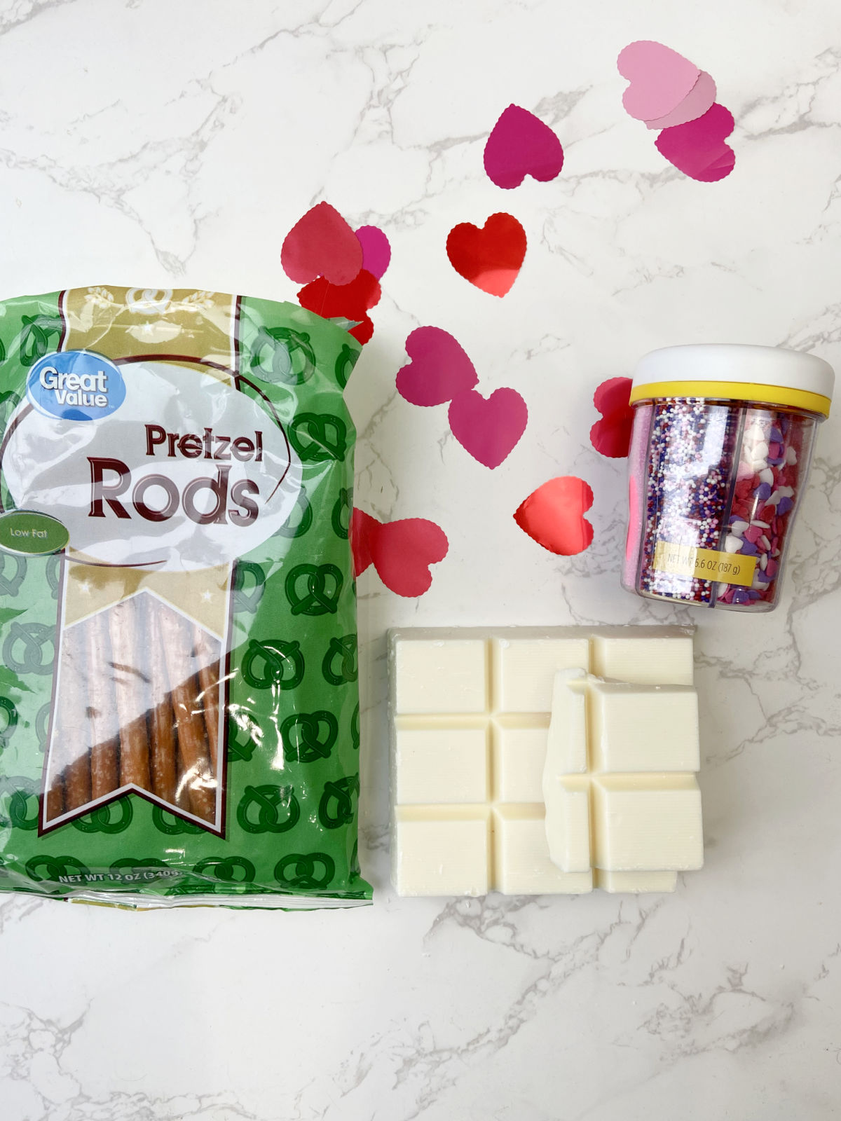 ingredients of pretzel rods, almond bark and valentine sprinkles. 