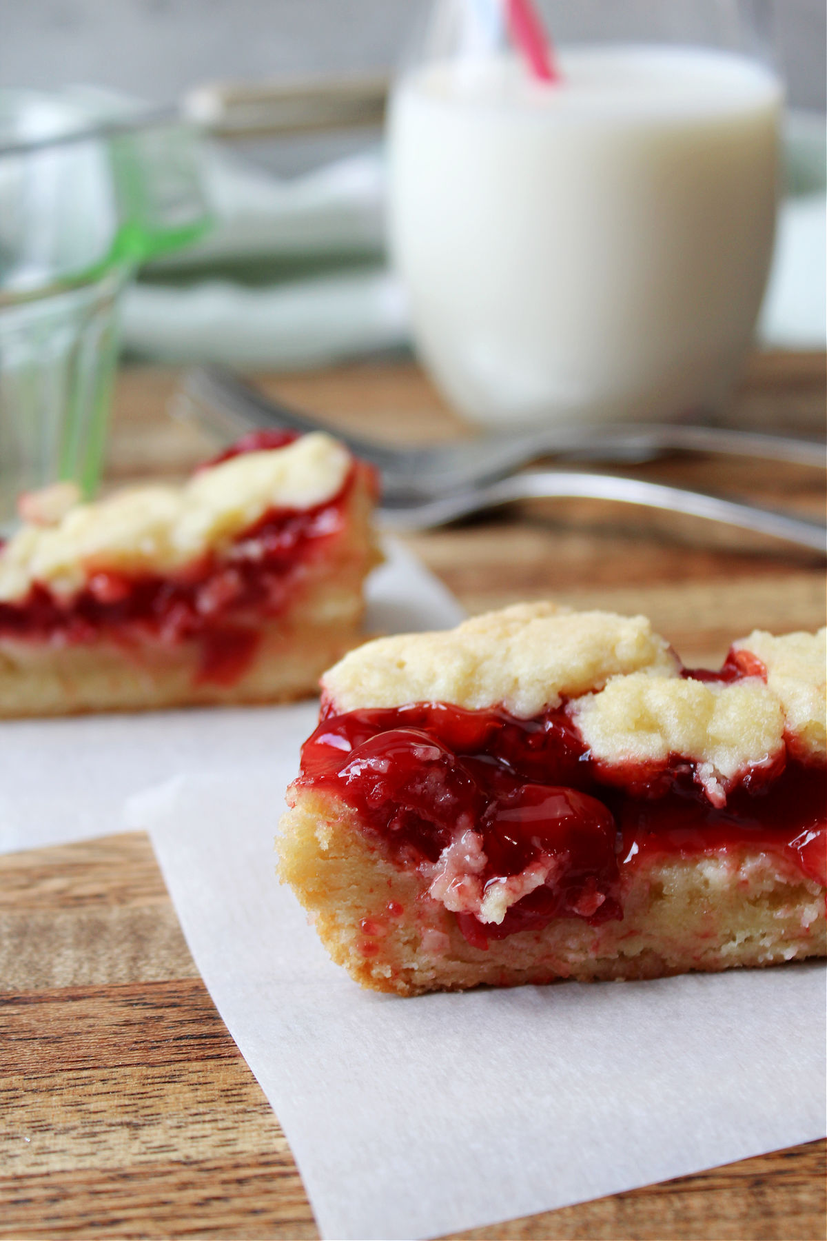 Easy cherry bars with a glass of milk behind. 
