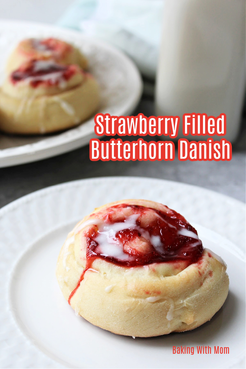 strawberry butterhorn danish on a white plate.