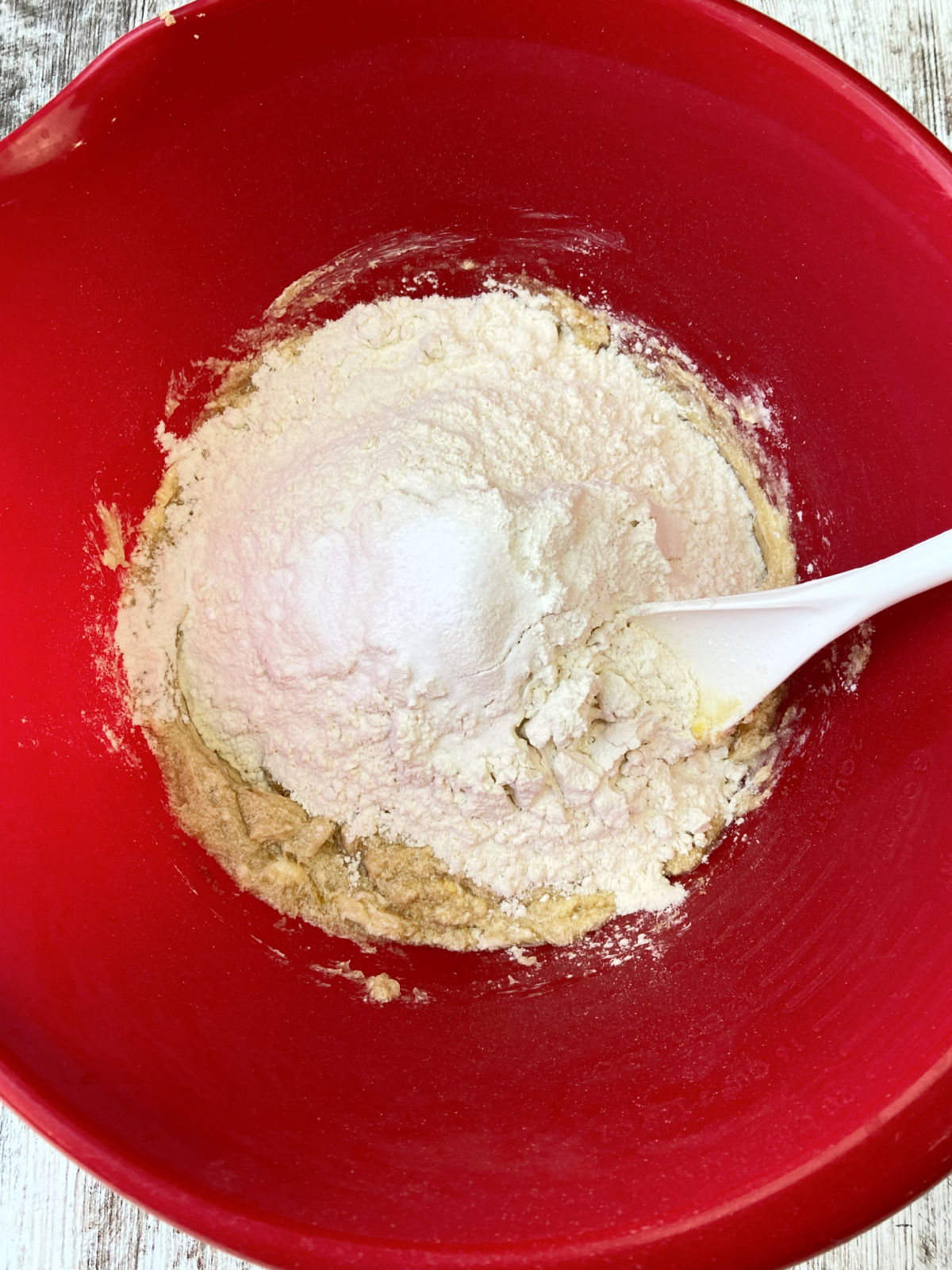 flour and salt added to a red bowl. 